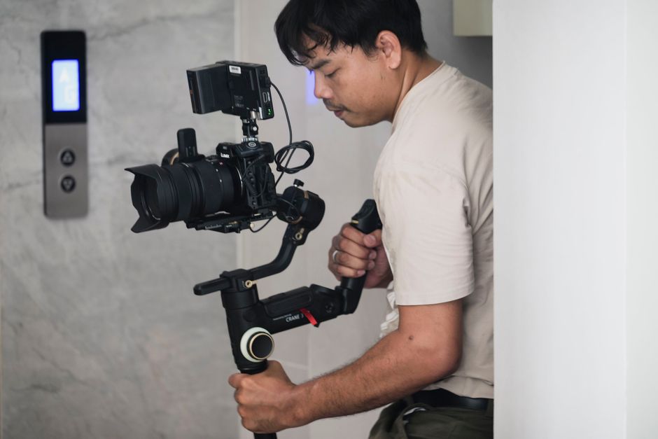 A professional wedding videographer holding a cinema camera, capturing a romantic moment